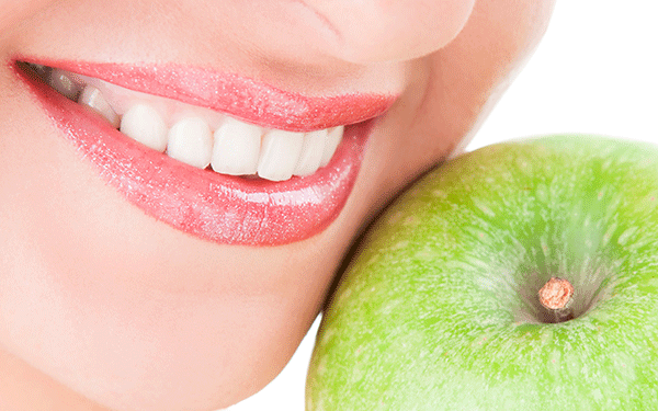 mujer sonriendo con una manzana
