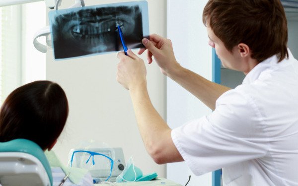 dentista enseñando una radiografía a un joven